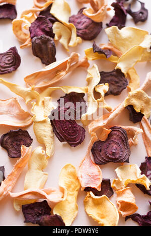 Vari chip di vegetali come sfondo, copia dello spazio. Assortiti bietola disidratata, carota, zucca chip di vegetali - vegano sani snack. Foto Stock