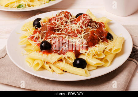 Penne pasta con le polpette di carne in salsa di pomodoro in una piastra bianca Foto Stock