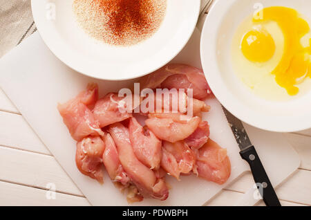 Freschi caserecci croccanti bocconcini di pollo ingredienti su tavola in legno rustico Foto Stock