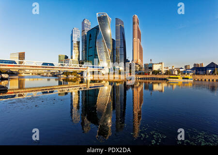 Alti edifici di Moscow International Business Center (MIBC) e Bagratiòn ponte pedonale si riflette nel fiume Moskva. Mosca, Russia. Foto Stock