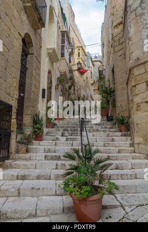 Una ripida scalinata in pietra che conduce fino ad una strada stretta nella vecchia città di Birgu - noto anche come Vittoriosa - a Malta. Foto Stock