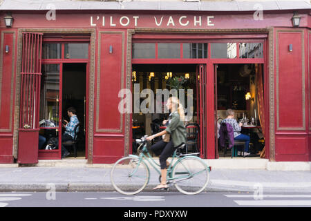 Parigi - bicicletta donna ciclismo passato l'L'ilot Vache ristorante sull'Ile de la Cite a Parigi, in Francia, in Europa. Foto Stock