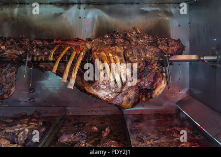 Il bue arrosto su uno spiedino, porzioni tagliate nelle vaschette di contenimento, Baviera, Germania Foto Stock