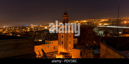 Vista dell'illuminato città vecchia di notte, moschea con minareto, Fes-Boulemane, Fez, in Marocco Foto Stock
