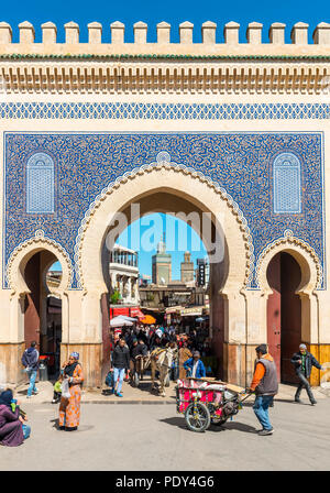 La gente del posto nella parte anteriore del Bab Boujeloud, Blue Gate di Fes, Minareto della madrasa Madrasa Bou Inania, Medina di Fez, Marocco Foto Stock