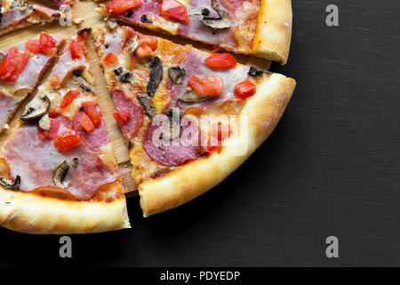 Pane appena sfornato pizza su sfondo nero, primo piano. Foto Stock