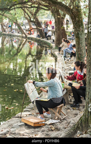 Il 18 ottobre 2014. Hongcun Village, Cina. Studenti locali delineando lo scenario in prossimità di un antico e pittoresco villaggio. Foto Stock