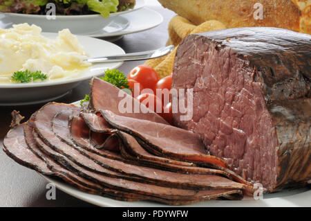 Tagliate a fette sottili slow Cucinato arrosto di manzo con purè di patate e insalata mista Foto Stock