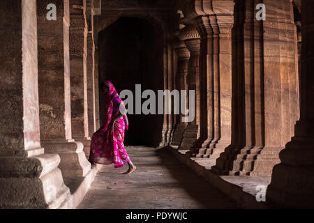 Signora in saree camminare badami tempio nella grotta corridoio Foto Stock