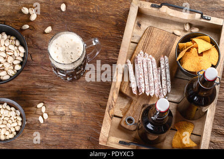 Birra e spuntini su sfondo di legno. Vista superiore Foto Stock