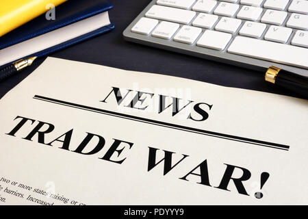 Giornale con titolo guerra commerciale su una scrivania. Foto Stock