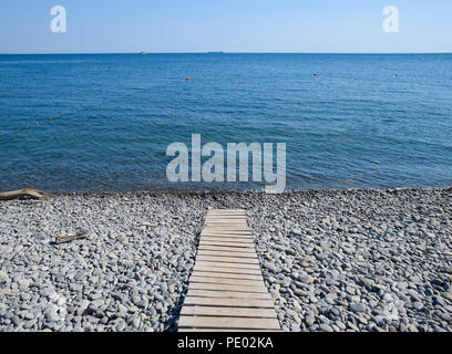 Percorso di legno al mare. Pavimento di assi sul percorso verso il mare. Foto Stock