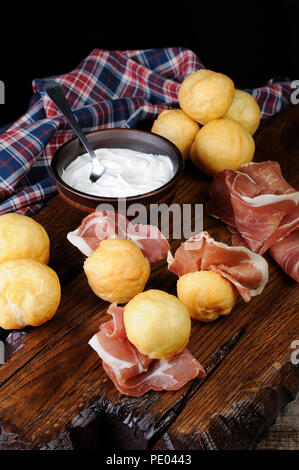 Coccoli è un antipasto dall'Italia. Impasto per pizza sfere vengono fritti e cosparsi di sale, servita con prosciutto e formaggio. Cibo tradizionale durante ch Foto Stock