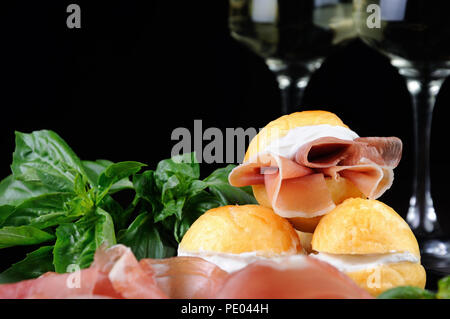 Coccoli è un antipasto dall'Italia. Impasto per pizza sfere vengono fritti e cosparsi di sale, servita con prosciutto e formaggio. Cibo tradizionale durante ch Foto Stock