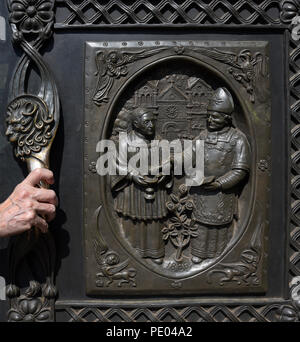 Una donna si apre il bronzo massiccio porte di ingresso presso la Cattedrale Basilica di San Francesco di Assisi a Santa Fe, New Mexico. Foto Stock