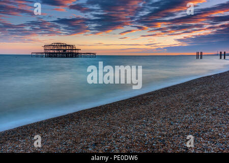 Il vecchio distrutto Molo Ovest di Brighton, Regno Unito, dopo il tramonto Foto Stock