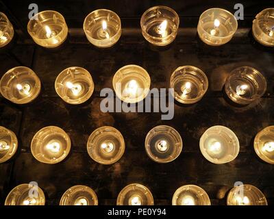 Candele in una chiesa vicino con sfondo scuro Foto Stock