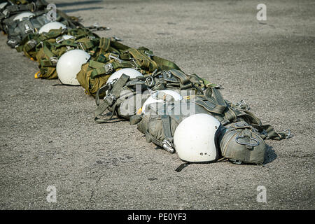 Fila di T-10 paracadute tattico borsa con paracadute di riserva e casco a terra a prepararsi per paracadutista al funzionamento con spazio di copia Foto Stock