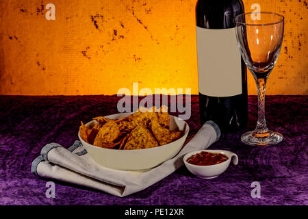 Nachos, Salsla, vetro e bottiglia di vino Foto Stock