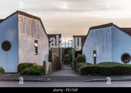 Suburban strada residenziale sentiero tra inglese insolito case bianche. Foto Stock