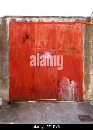Rosso vivo la porta di metallo su un garage in Cessenon-sur-Orb, Francia Foto Stock