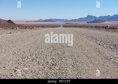 Basso angolo di vista di aprire strada di ghiaia all orizzonte nel deserto, Namibia Foto Stock