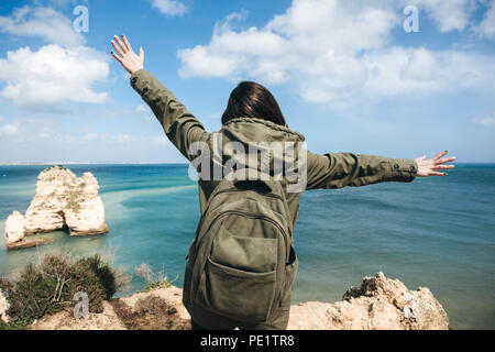 Vista posteriore di donna alza le braccia per aspettare che la bottiglia di  gel di alcol cade dal cielo nel campo di riso.Campagna per prevenire la  diffusione della corona Foto stock 