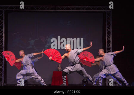 Chania, Grecia. 10 Ago, 2018. Shaolin partecipanti visto eseguendo con ventole a una mostra.Shaolin la leggenda è un gruppo di Kung Fu Shaolin Masters. Essi volare in aria, stupire con le loro spade e rompere le pietre nel loro corpo o di testa e i loro corpi touch su lance, il tutto in un atmosfera di opaco con candele accese e il paesaggio mozzafiato. Credito: Nikolas Joao Kokovlis SOPA/images/ZUMA filo/Alamy Live News Foto Stock