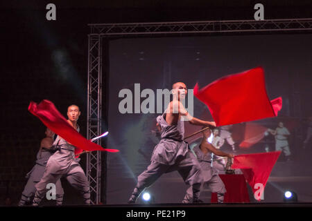 Chania, Grecia. 10 Ago, 2018. Shaolin partecipanti visto eseguendo con le bandiere rosse in occasione di una mostra.Shaolin la leggenda è un gruppo di Kung Fu Shaolin Masters. Essi volare in aria, stupire con le loro spade e rompere le pietre nel loro corpo o di testa e i loro corpi touch su lance, il tutto in un atmosfera di opaco con candele accese e il paesaggio mozzafiato. Credito: Nikolas Joao Kokovlis SOPA/images/ZUMA filo/Alamy Live News Foto Stock