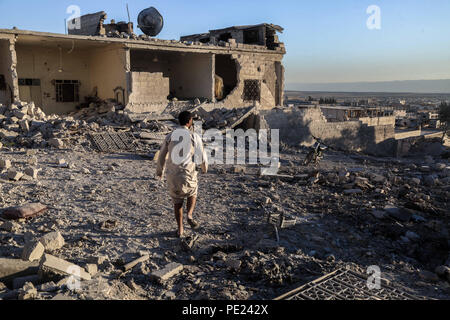 Idlib, Siria. 10 Ago, 2018. Un uomo è visto camminare al fianco di un edificio colpito.9 Anti militanti del governo sono morti e più di 45 feriti come un risultato di pesante bombardamento della città di Khan Shikhon dal regime siriano di aeroplani militari e gli elicotteri. Credito: Anas Aldyab SOPA/images/ZUMA filo/Alamy Live News Foto Stock