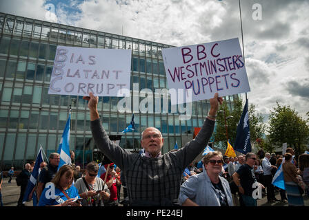 Glasgow, Renfrewshire, Regno Unito. 11 Ago, 2018. Un uomo può contenere fino a due segnali all'esterno l'edificio mentre si guarda qualcuno parlare sul palco.centinaia di manifestanti sono scesi in strada di Glasgow per protestare contro la BBC per il travisamento della Scozia e le notizie di polarizzazione che è a favore di Westminster. Credito: Stewart Kirby SOPA/images/ZUMA filo/Alamy Live News Foto Stock