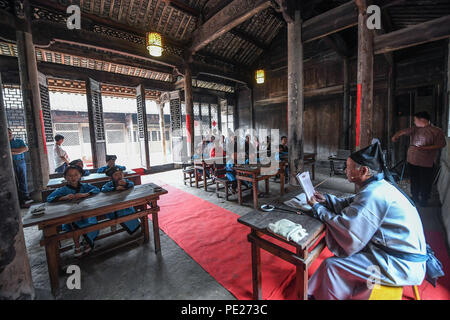 Changxing cinese della provincia dello Zhejiang. 12 Ago, 2018. Gli studenti hanno una classe tradizionale a un vecchio-stile scuola privata nel villaggio di Zhongshan nella contea di Changxing, est della Cina di Provincia dello Zhejiang, Agosto 12, 2018. Credito: Xu Yu/Xinhua/Alamy Live News Foto Stock