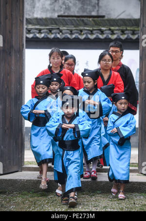 Changxing cinese della provincia dello Zhejiang. 12 Ago, 2018. Gli studenti a piedi in un vecchio stile a scuola privata di sperimentare una classe tradizionale nel villaggio di Zhongshan nella contea di Changxing, est della Cina di Provincia dello Zhejiang, Agosto 12, 2018. Credito: Xu Yu/Xinhua/Alamy Live News Foto Stock