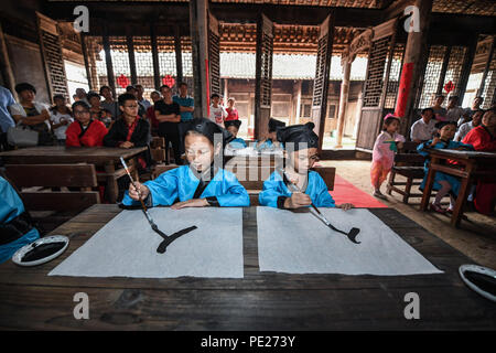 Changxing cinese della provincia dello Zhejiang. 12 Ago, 2018. Agli studenti di scrivere "ren" significato persona presso un vecchio stile di scuola privata nel villaggio di Zhongshan nella contea di Changxing, est della Cina di Provincia dello Zhejiang, Agosto 12, 2018. Credito: Xu Yu/Xinhua/Alamy Live News Foto Stock