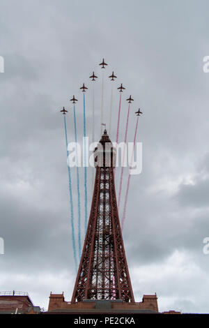 Blackpool, Regno Unito. 12 Agosto 2018 - RAF frecce rosse sorvolare la Blackpool Tower alla fine della annuale airshow di Blackpool. Le frecce rosse ha volato per lo sfondo di un emergente tempesta, ed eseguita per una folla di decine di migliaia di lungo la passeggiata di Blackpool. Credito: Benjamin Wareing/Alamy Live News Foto Stock