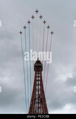 Blackpool, Regno Unito. 12 Agosto 2018 - RAF frecce rosse sorvolare la Blackpool Tower alla fine della annuale airshow di Blackpool. Le frecce rosse ha volato per lo sfondo di un emergente tempesta, ed eseguita per una folla di decine di migliaia di lungo la passeggiata di Blackpool. Credito: Benjamin Wareing/Alamy Live News Foto Stock