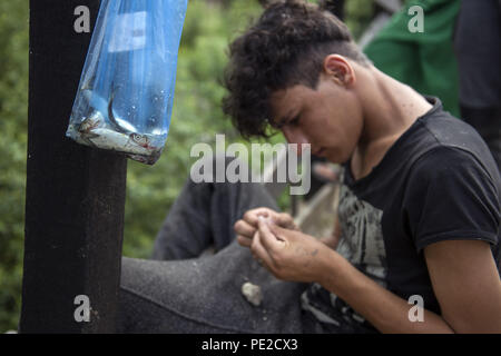 Velika Kladusa, Bosnia. Agosto 12, 2018 - Velika Kladusa, Velika Kladusa, Bosnia e Erzegovina - un rifugiato si vede la pesca nel fiume vicino al camp.profughi che tentano di fare il loro modo nell'Unione europea attraverso la Bosnia vivono qui in Velika Kladusa nel terribile e in condizioni inumane in una tenda in città dopo la chiusura dell'ex rotta balcanica, tende improvvisate sono per la maggior parte solo tetto per uomo, donna e bambini. Credito: ZUMA Press, Inc./Alamy Live News Foto Stock