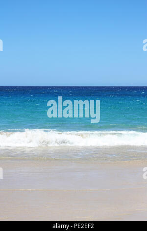 Multi tinte blu nell'Oceano Pacifico con piccole onde rotoli sulla sabbia bianca al Hapuna Beach, Waimea, Hawaii, STATI UNITI D'AMERICA Foto Stock