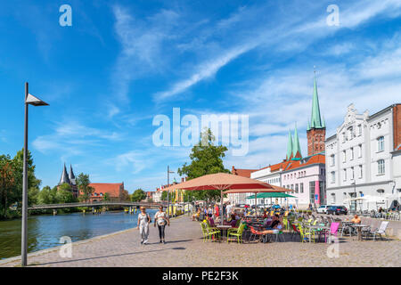 Cafè sul marciapiede sulle rive del fiume Trave, Lubecca, Schleswig-Holstein, Germania Foto Stock