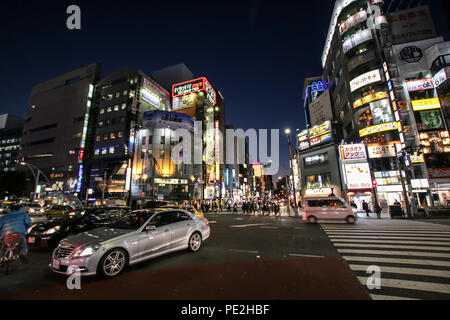 Un incrocio con negozi, aziende, automobili e attraversamenti di notte nel quartiere di Ueno, Tokyo, Giappone. Foto Stock