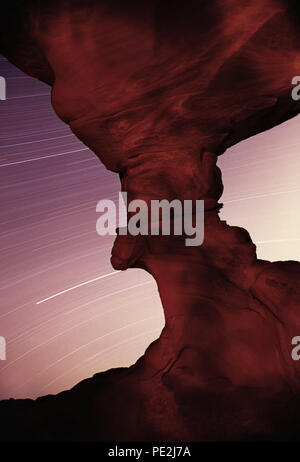 A diverse ore di esposizione delle tracce stellari da sotto Arch Rock in il Parco della Valle di Fire State, NV. Foto Stock