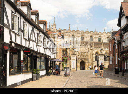 Giovane camminando in College St Gloucester, con la cattedrale in background, Gloucestershire, England, Regno Unito Foto Stock