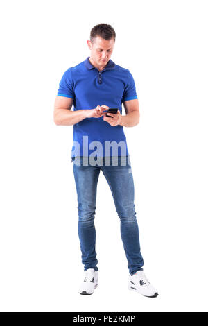 Giovane adulto uomo informale la digitazione e interagendo con gli smart phone utilizzando il dito sul touch screen. Corpo pieno isolati su sfondo bianco. Foto Stock