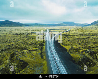Paesaggio di antenna di Islanda, drone vista autostrada strada nel verde dei campi di origine vulcanica Foto Stock