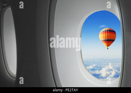 Viaggi da sogno, mongolfiera volare nel cielo visto dalla finestra del velivolo, sorpresa concept Foto Stock