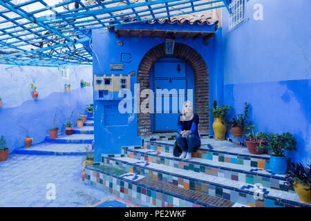 Ragazza bionda è in visita a Chefchaouen (Chaouen) città in Marocco notato per i suoi edifici in sfumature di blu. Foto Stock