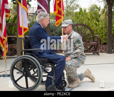 Texas Gov. Greg Abbott awards il Texas cuore viola a Sgt. Michael Cantu, con una cerimonia tenutasi a Fort Sam Houston a San Antonio, Sett. 24, 2015. Cantu e altri tre Texas guardie nazionali sono state distribuite con il primo squadrone, 112reggimento di cavalleria, che è stato parte della forza multinazionale e osservatori (MFO) missione in Egitto, quando essi hanno ricevuto le loro ferite. (U.S. Esercito nazionale Guard foto di Sgt. 1. Classe Malcolm McClendon) Foto Stock