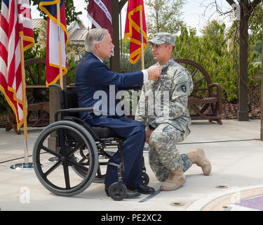 Texas Gov. Greg Abbott awards il Texas cuore viola a Spc. James Burkett, con una cerimonia tenutasi a Fort Sam Houston a San Antonio, Sett. 24, 2015. Burkett e altri tre Texas guardie nazionali sono state distribuite con il primo squadrone, 112reggimento di cavalleria, che è stato parte della forza multinazionale e osservatori (MFO) missione in Egitto, quando essi hanno ricevuto le loro ferite. (U.S. Esercito nazionale Guard foto di Sgt. 1. Classe Malcolm McClendon) Foto Stock