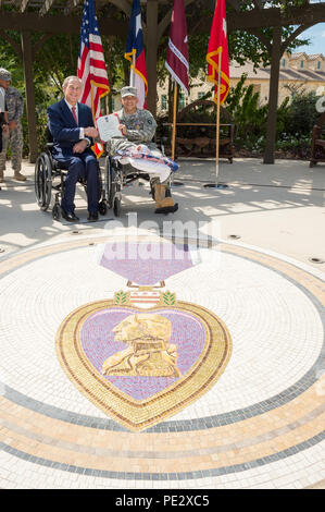 Texas Gov. Greg Abbott awards il Texas cuore viola a Spc. Jose Romo nel corso di una cerimonia svoltasi a Fort Sam Houston a San Antonio, Sett. 24, 2015. Romo e altri tre Texas guardie nazionali sono state distribuite con il primo squadrone, 112reggimento di cavalleria, che è stato parte della forza multinazionale e osservatori (MFO) missione in Egitto, quando essi hanno ricevuto le loro ferite. (U.S. Esercito nazionale Guard foto di Sgt. 1. Classe Malcolm McClendon) Foto Stock