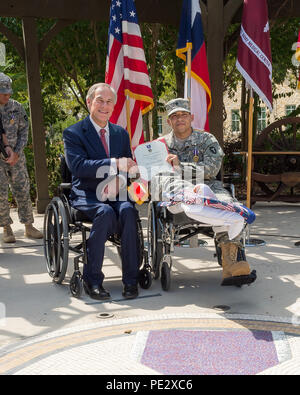 Texas Gov. Greg Abbott awards il Texas cuore viola a Spc. Jose Romo nel corso di una cerimonia svoltasi a Fort Sam Houston a San Antonio, Sett. 24, 2015. Romo e altri tre Texas guardie nazionali sono state distribuite con il primo squadrone, 112reggimento di cavalleria, che è stato parte della forza multinazionale e osservatori (MFO) missione in Egitto, quando essi hanno ricevuto le loro ferite. (U.S. Esercito nazionale Guard foto di Sgt. 1. Classe Malcolm McClendon) Foto Stock